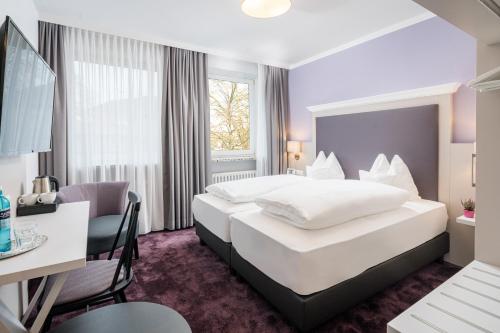 Hotelzimmer mit großem Bett und Schreibtisch