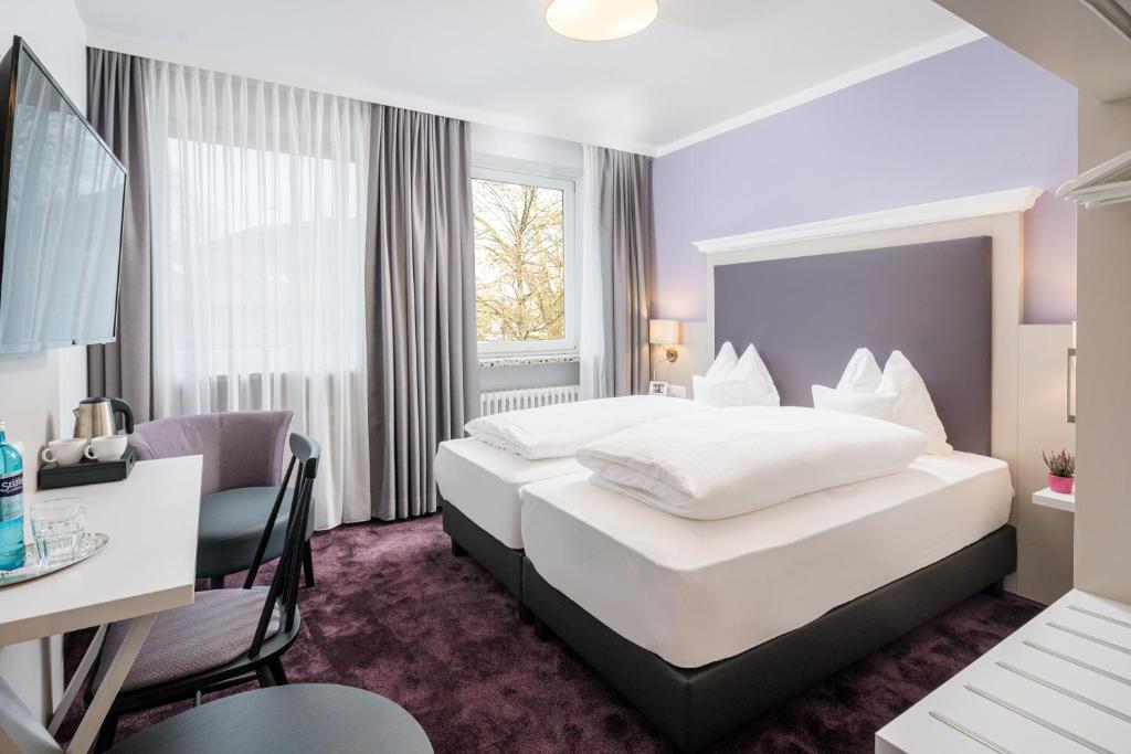 Hotelzimmer mit großem Bett und Schreibtisch